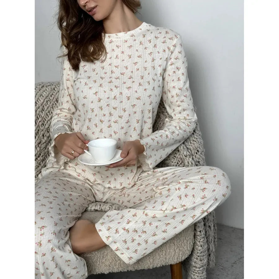 White floral print women's suit with bell sleeve top and wide leg trousers on hanger