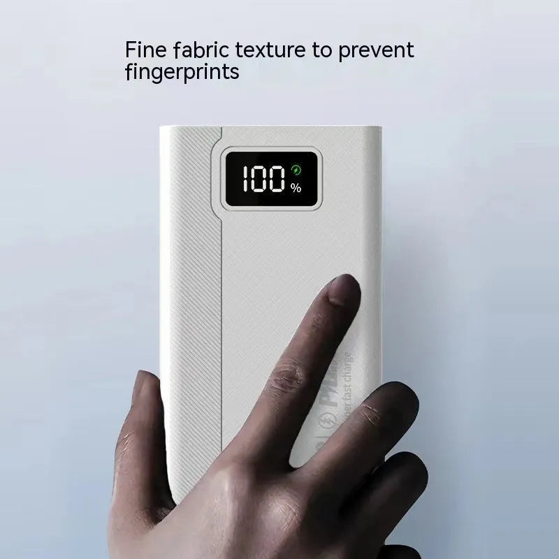 Black and white large capacity portable power bank with fast charging, showing size scale.