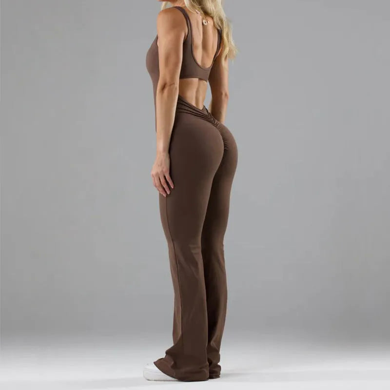 Black seamless women's yoga bodysuit jumpsuit with built-in chest pad, shown on model.