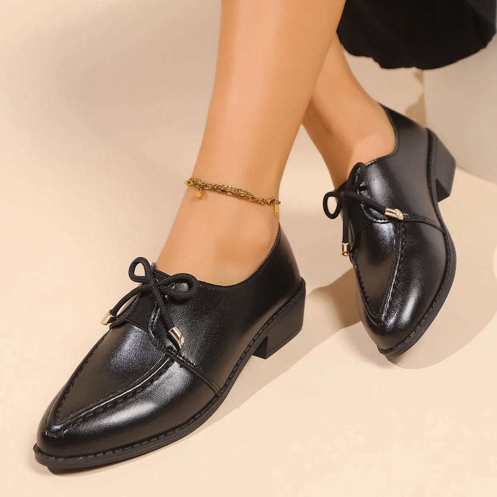 Women's casual leather shoes with a decorative bow on a pointed toe, showcasing a rubber sole.