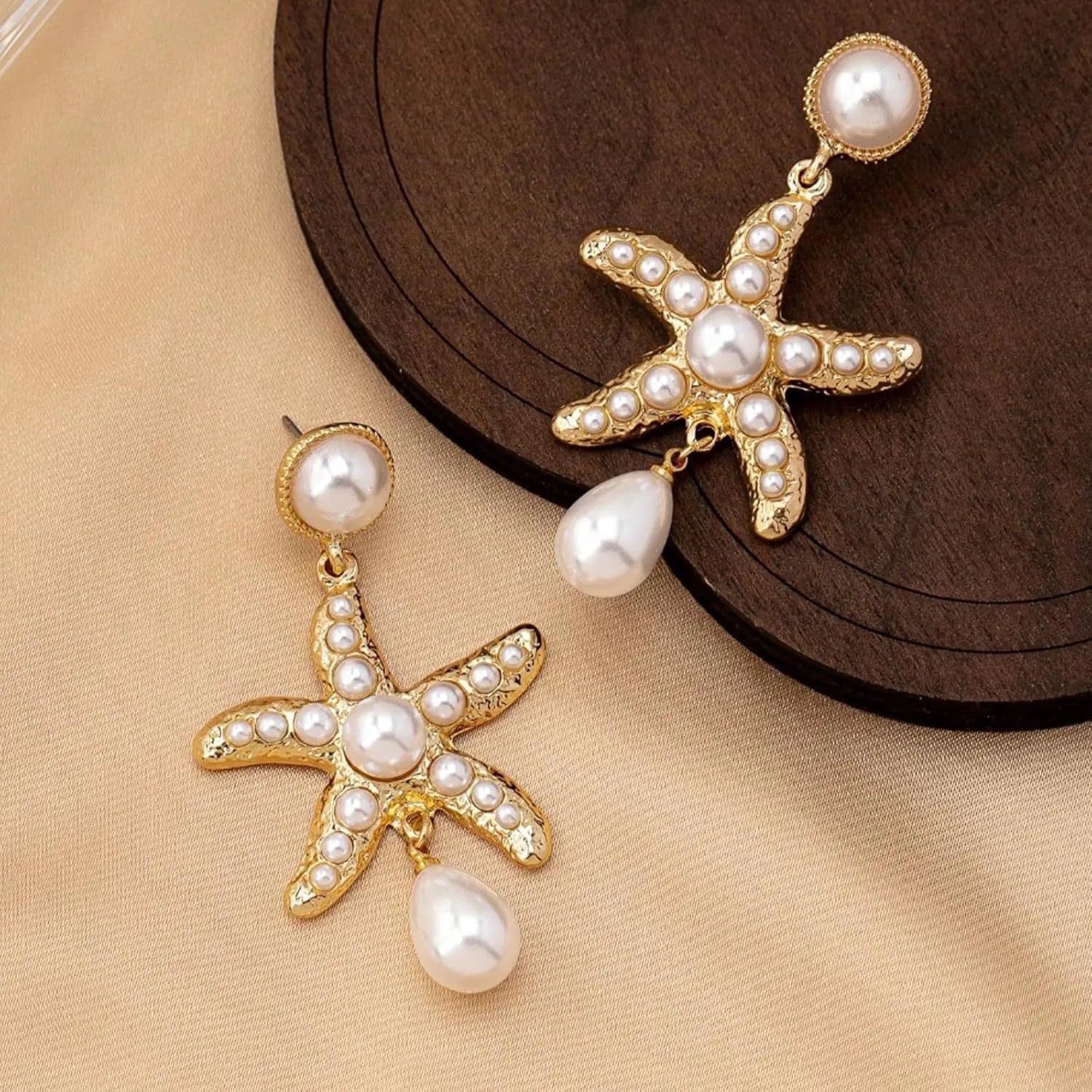 Women's silver-tone pearl starfish earrings on light background