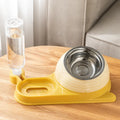Brown elevated cat bowl with attached water bottle dispenser on a white background