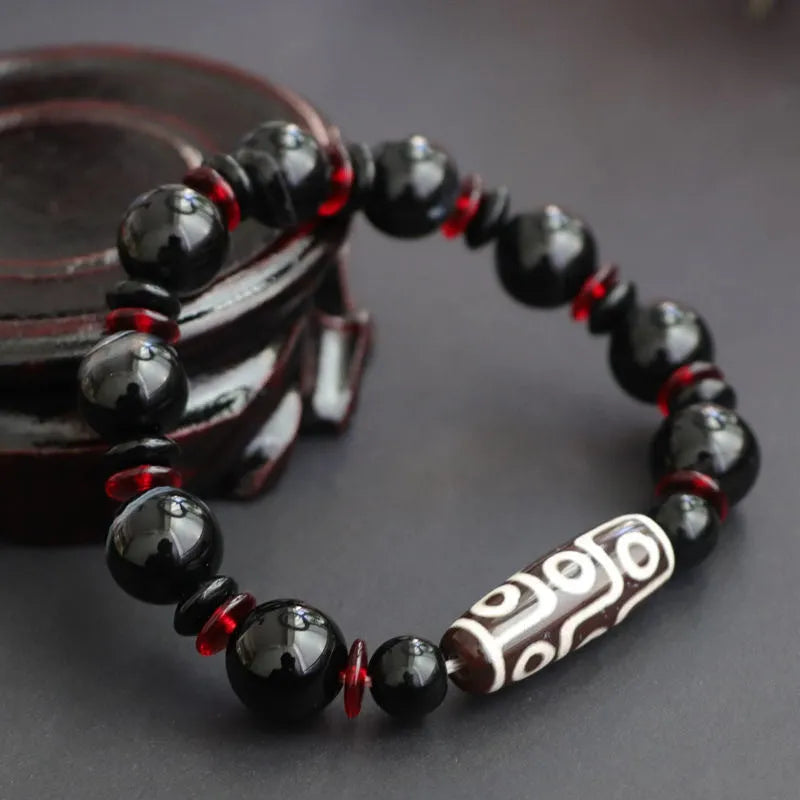 Black agate dzi bead bracelet with geometric 11mm beads on a hand-woven cord.