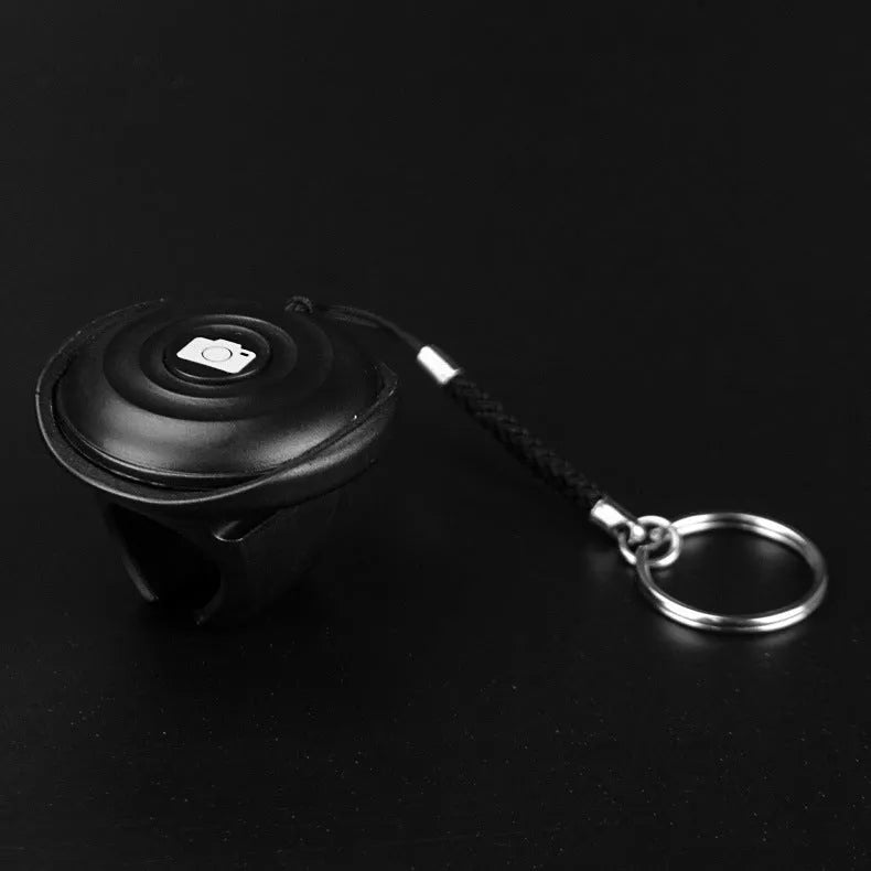 Black Bluetooth remote control for selfies with snap magnetic attachment showing compact design