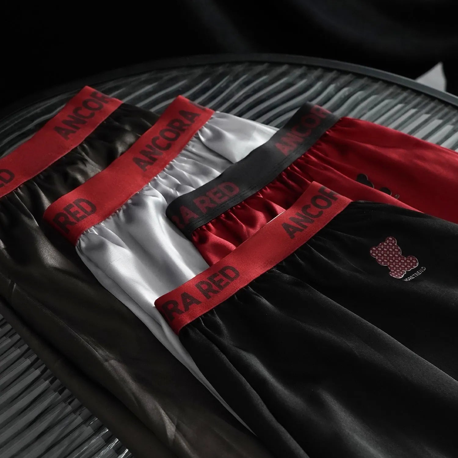 Solid colour men's boxer briefs in black, red, blue, silver, purple, and brown on a mid-waist fit.