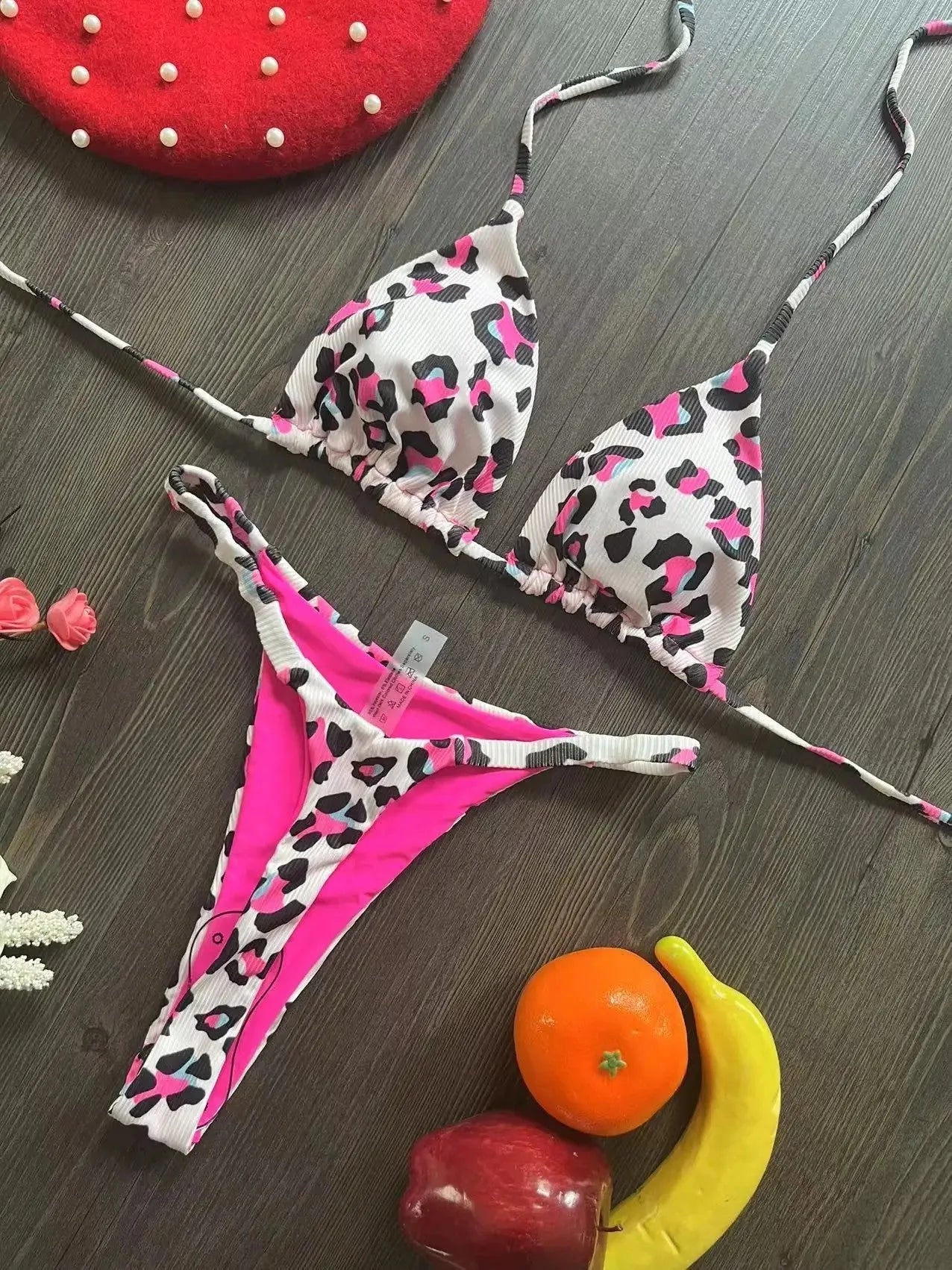 Women's printed bikini swimsuit on a hanger, showing briefs style and cotton lining detail.
