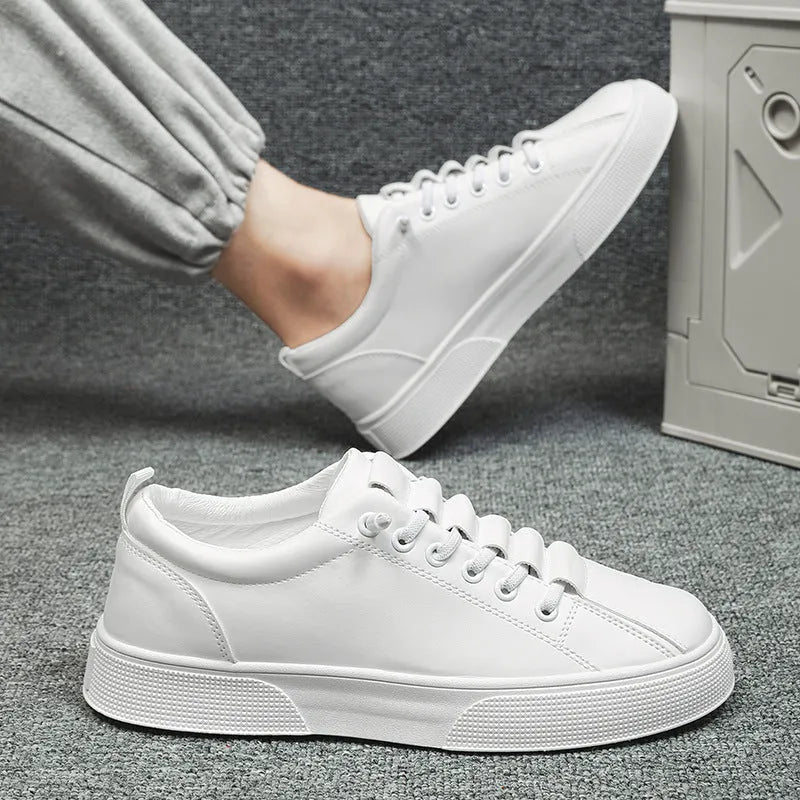 Men's black and white low top synthetic leather sports shoes with PVC sole on a plain background.