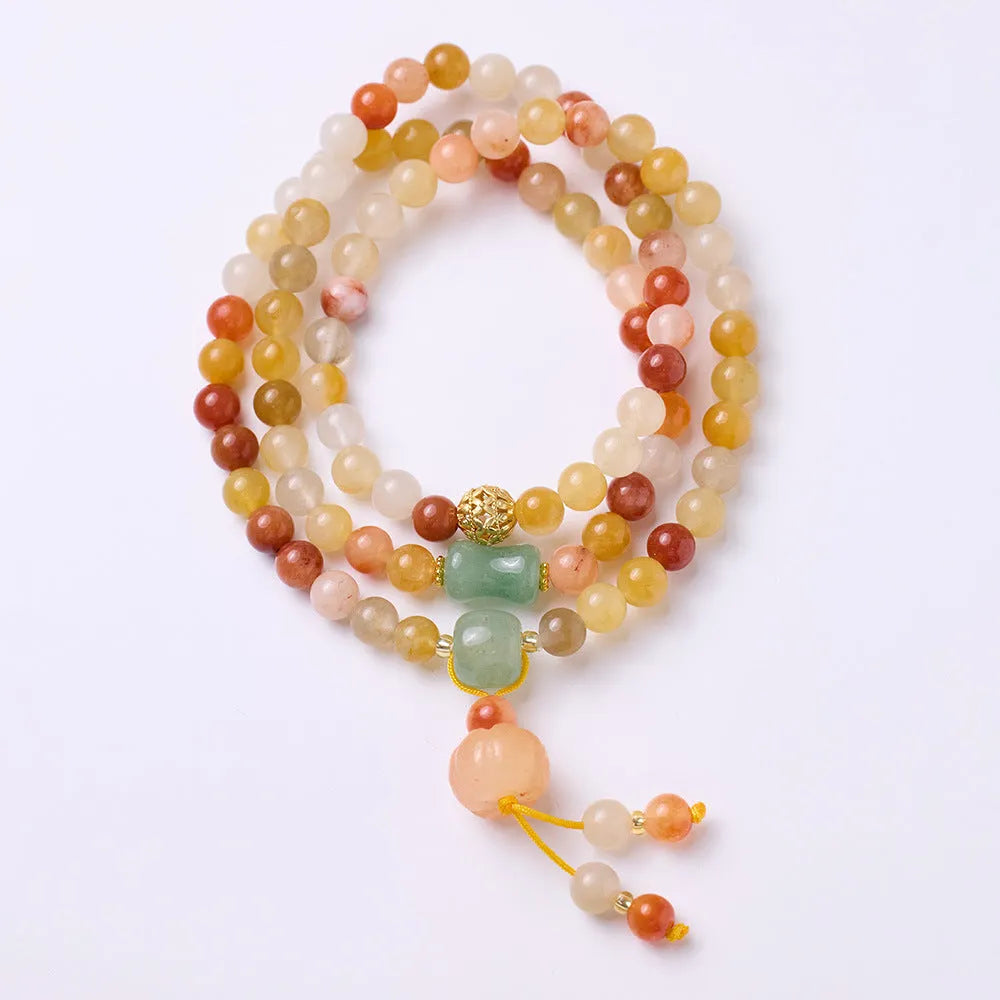 Handmade women's Jinsi Jade bracelet with three pumpkin beads and tassel on a wrist.