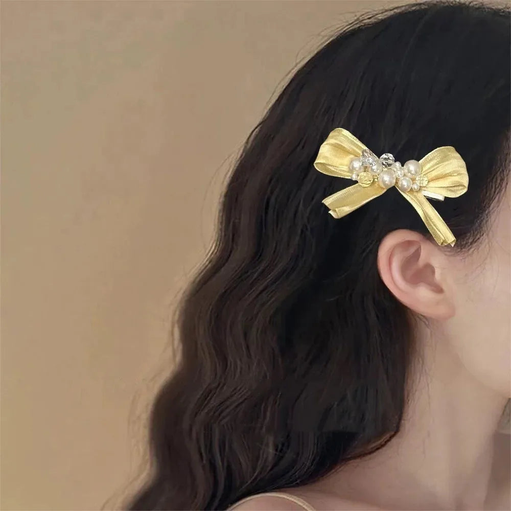 Yellow cloth bow barrette hair clip with rhinestone and pearl details on duckbill clip