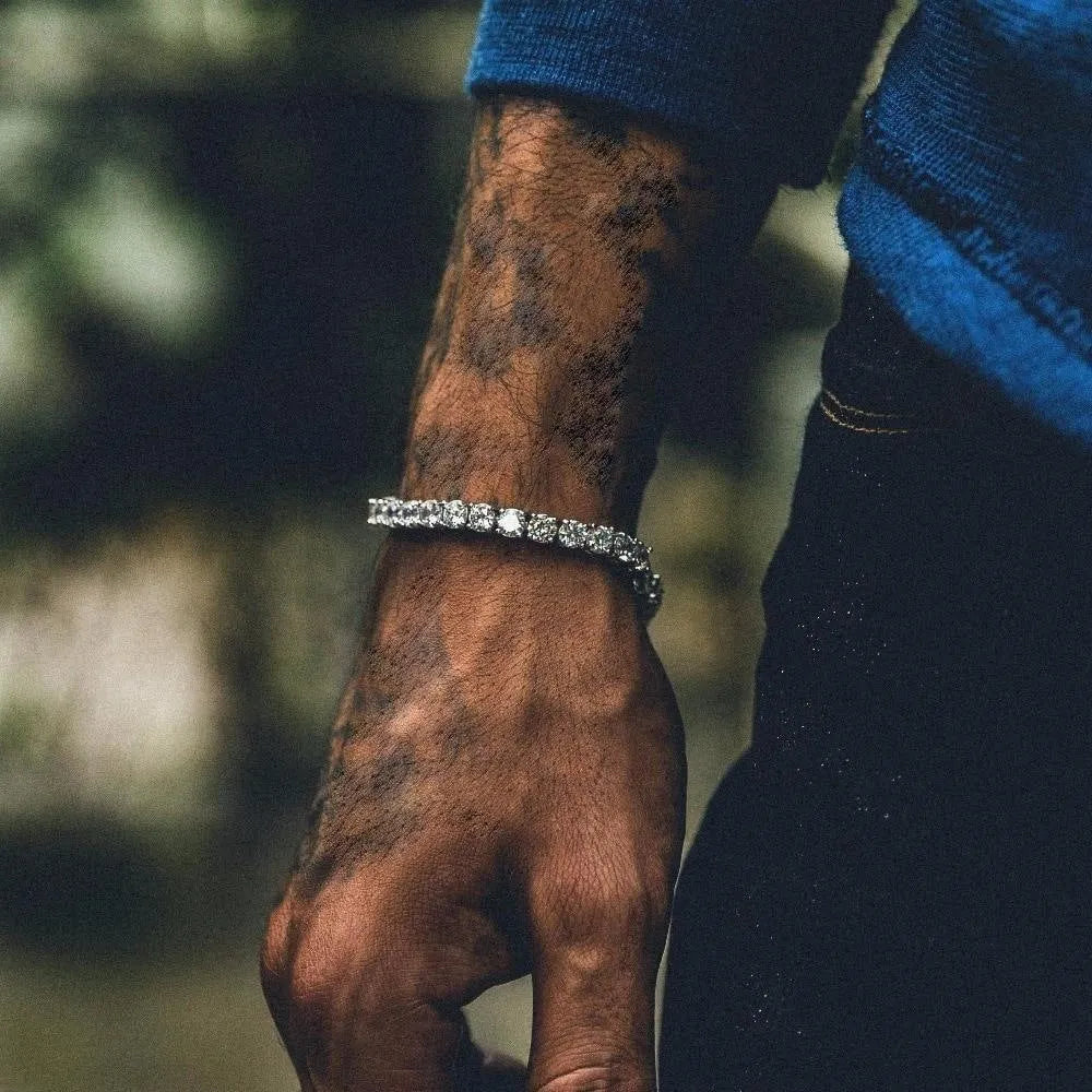 Men's silver geometric bracelet with a row of clear rhinestones and a gold tennis charm on a chain link.
