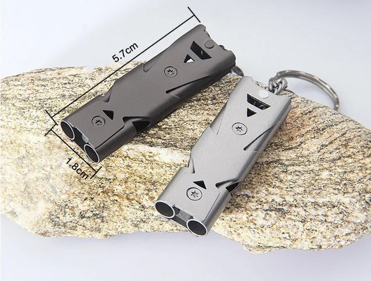 Compact keychain whistle in black and silver with keychain attachment for portable emergency signalling