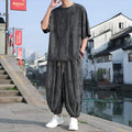 Men's lightweight knitted two-piece suit with short sleeves and cropped trousers in grey.