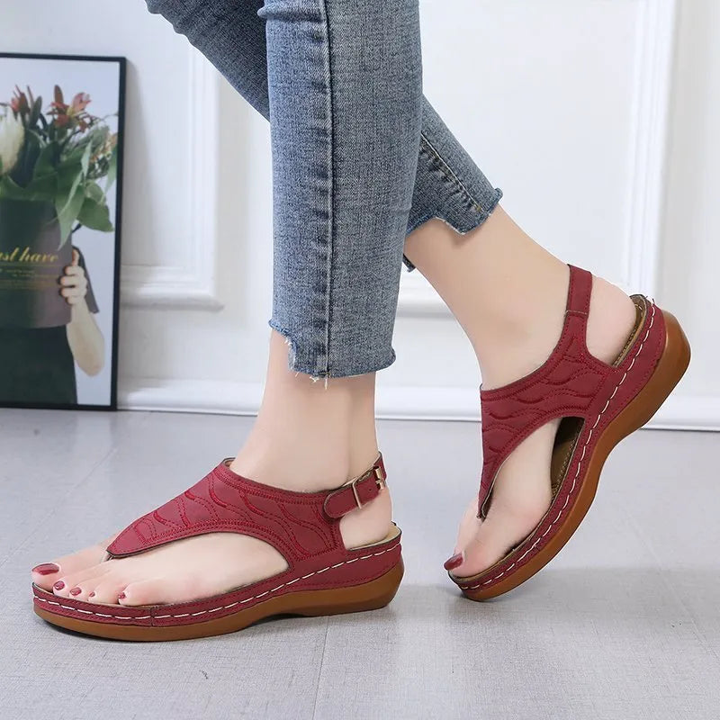 Women's black wedge heel sandals with an adjustable buckle back strap on a plain background.