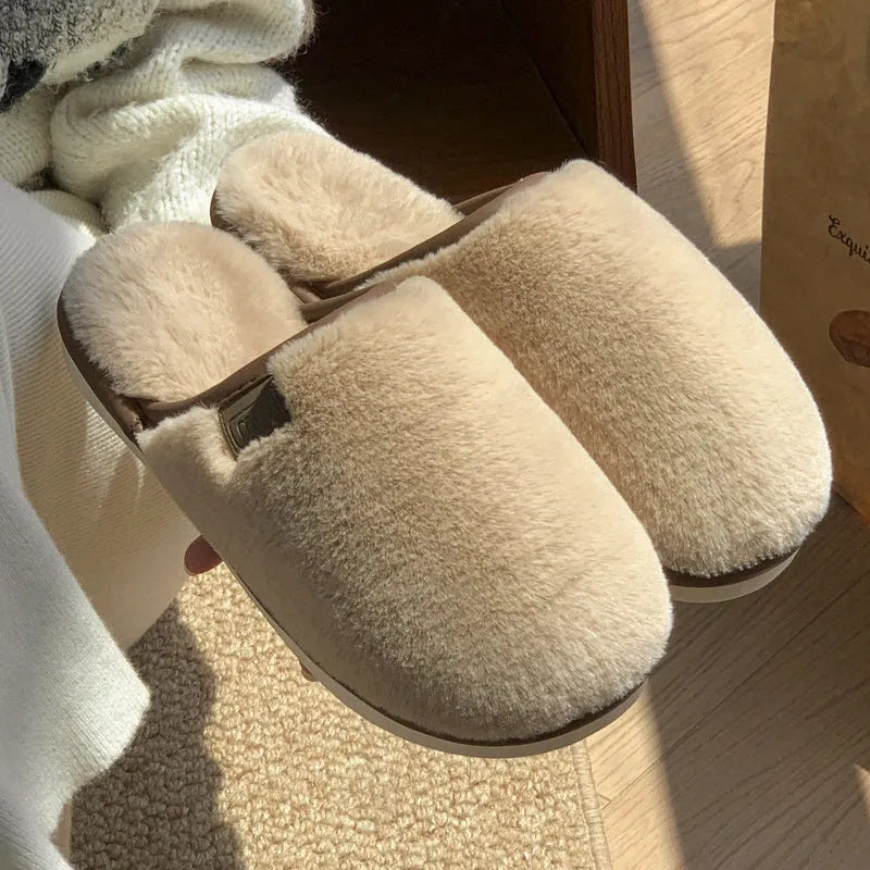 Blue winter plush slippers with non-slip PVC soles on a wooden floor.