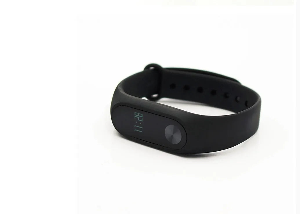 Black Xiaomi Mi Band 2 fitness tracker on wrist showing OLED display with heart rate reading