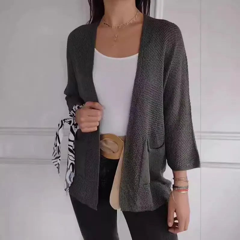 Women's longline waffle-textured cardigan coat in army green, showing pocket detail and nine-quarter sleeve length.