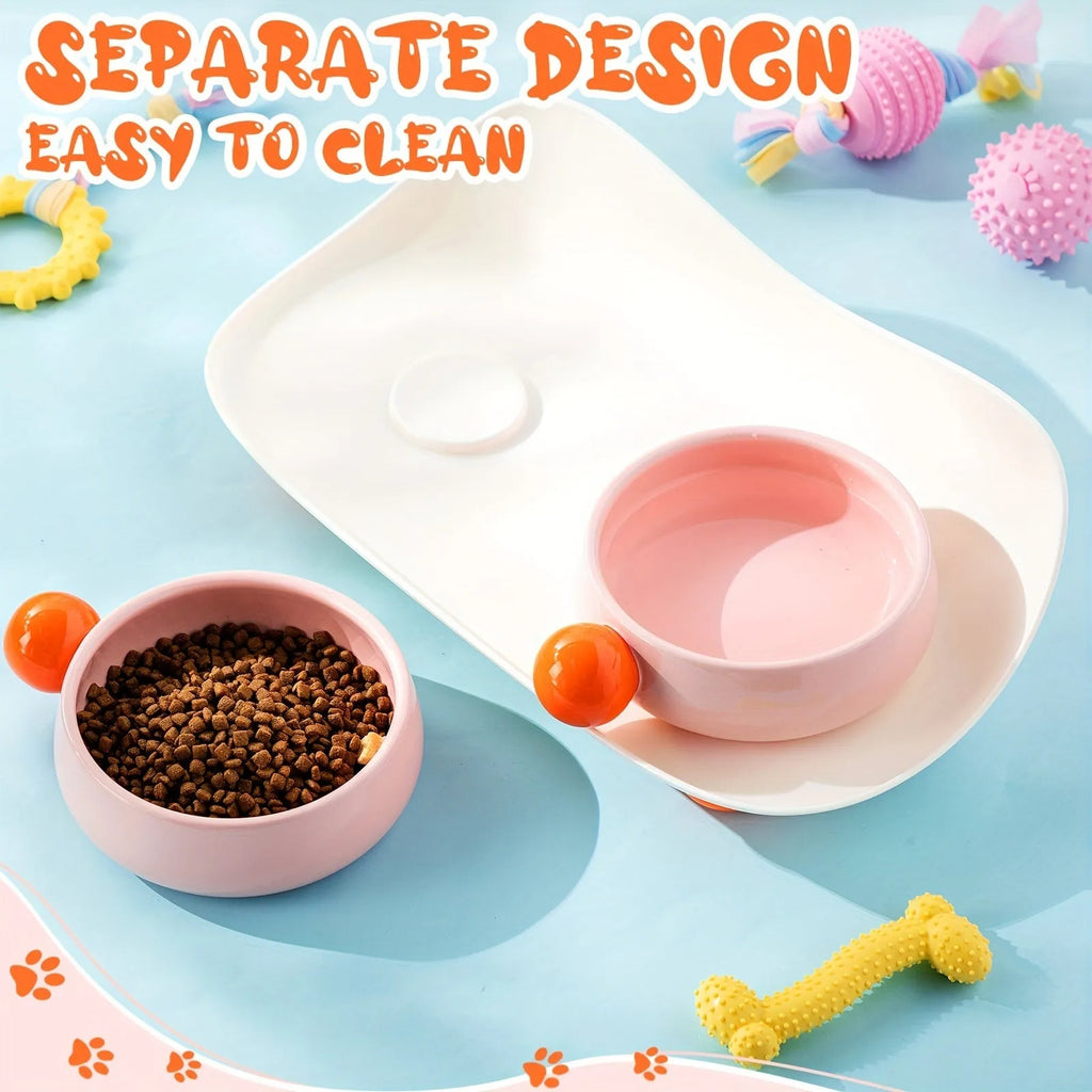 Two raised ceramic pet bowls with pink and yellow colours and grey non-slip silicone bases.
