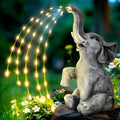 Resin elephant garden statue with a separate LED light strip on a patio.