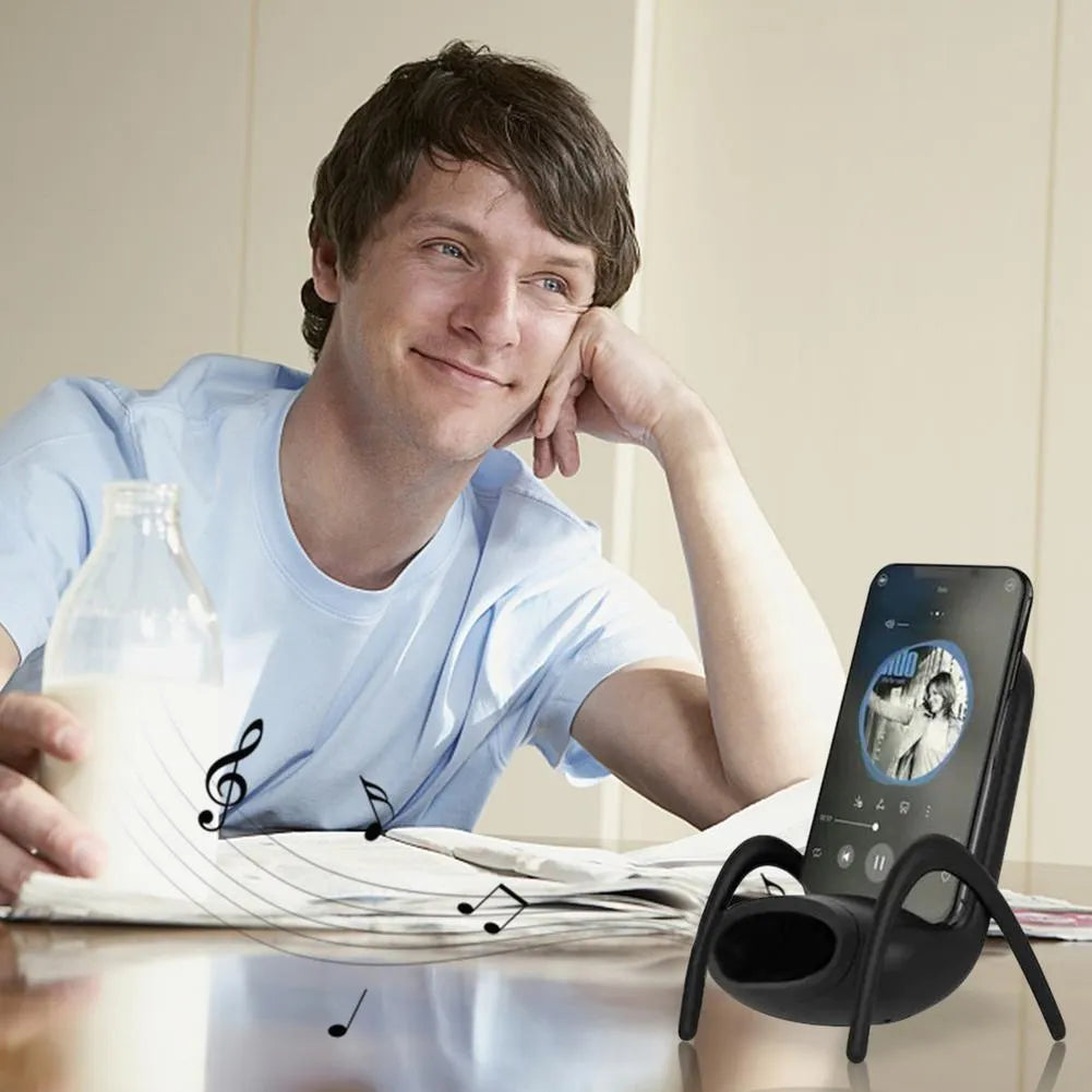 White mini chair shaped wireless charging stand holding a mobile phone at an angle