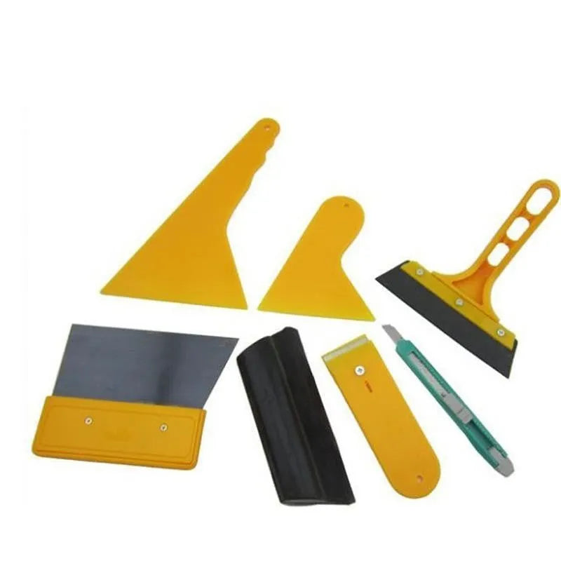 Seven-piece car foil tool set including scrapers, knives, tendon scraper, and pressing block on a table.