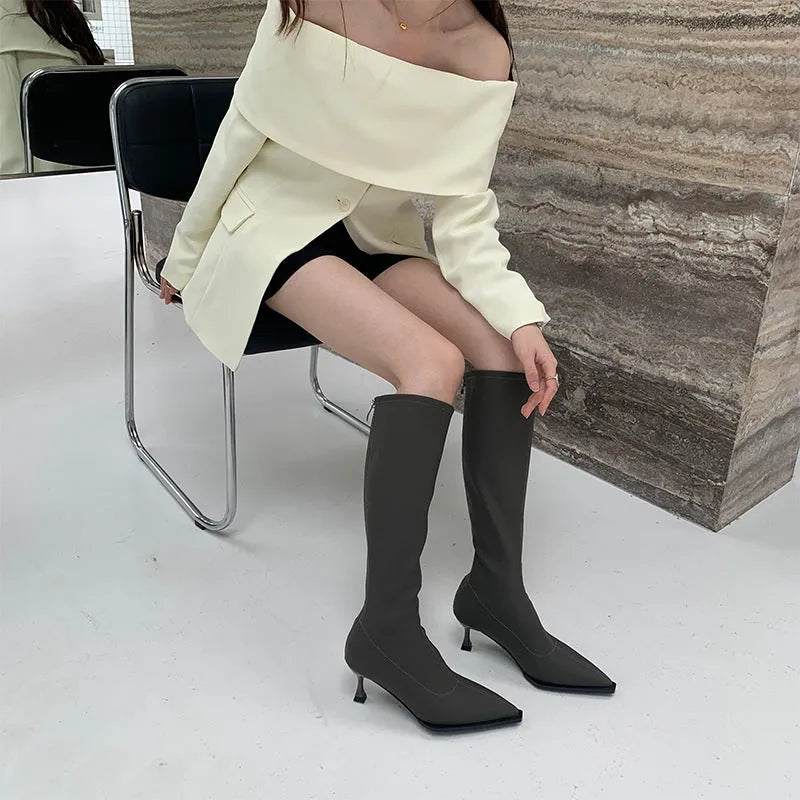 Black women's pointed toe below-the-knee boots with a stiletto heel and a back zipper.