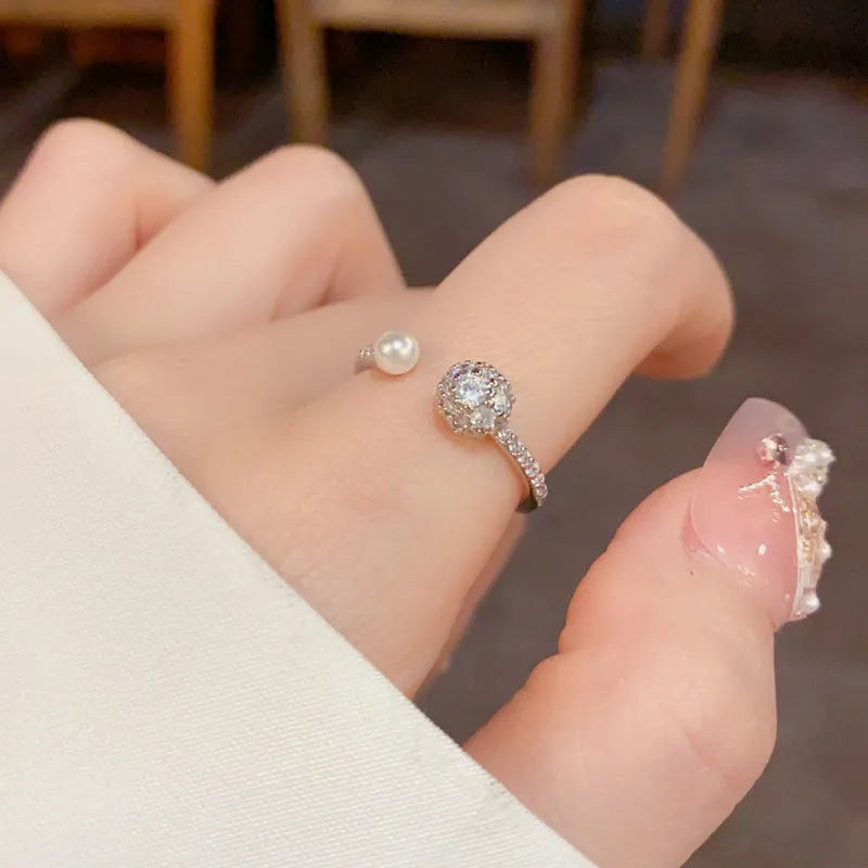 Open-end ring with round zircon stones and pearl accents in gold or silver plating