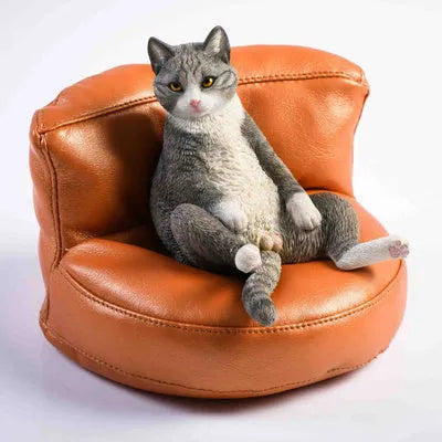 Lazy cat and sofa miniature car dashboard ornament made from resin, approximately 7.5cm high.