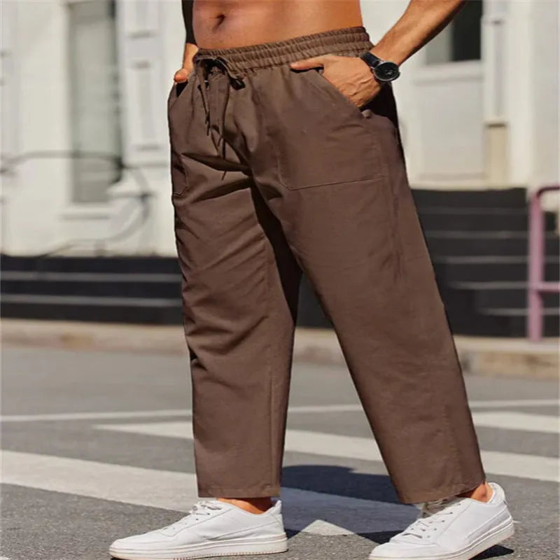 Man wearing straight-leg linen trousers in a solid colour with an elasticated waistband.