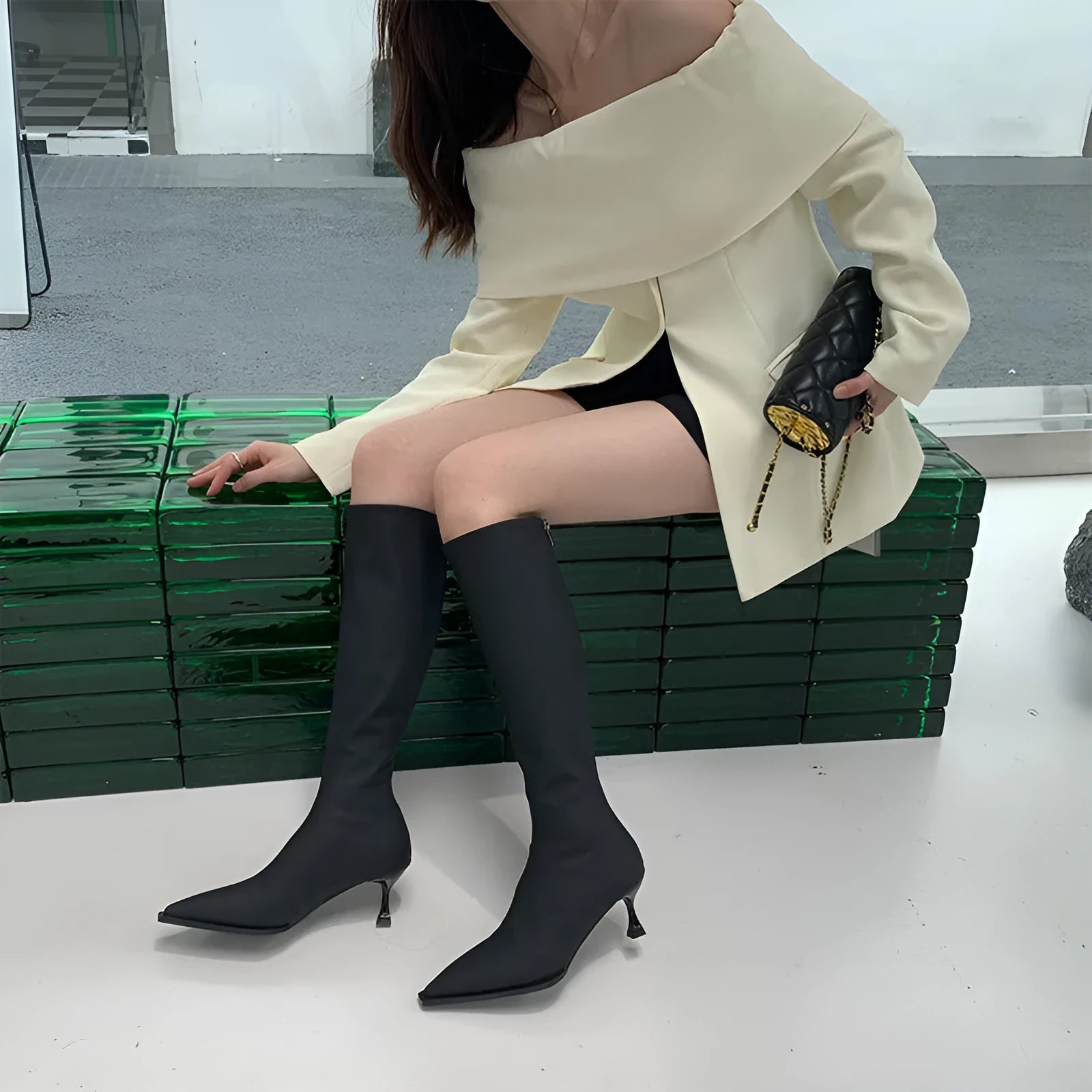 Black women's pointed toe below-the-knee boots with a stiletto heel and a back zipper.
