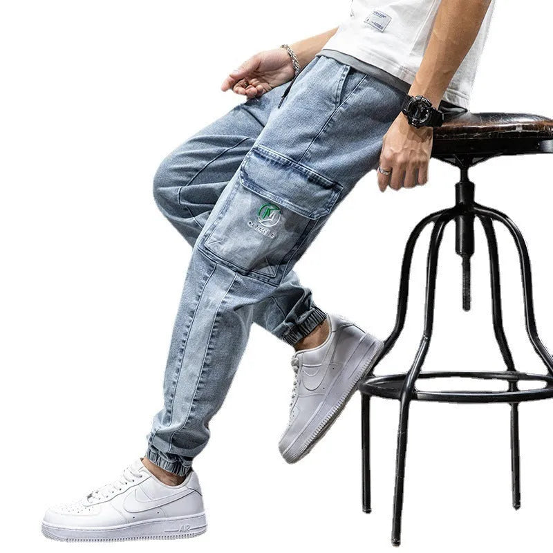 Men's loose fit straight leg cargo jeans in blue on a neutral background.