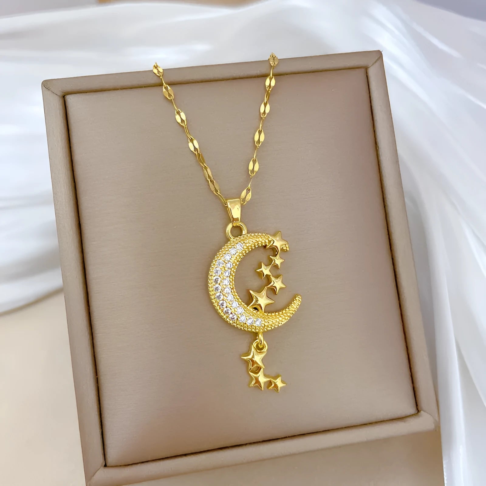Geometric moon pendant necklace with tassel on a stainless steel chain.