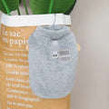 A blue coral fleece pet jacket for dogs or cats with a pull-ring fastening, laid flat.