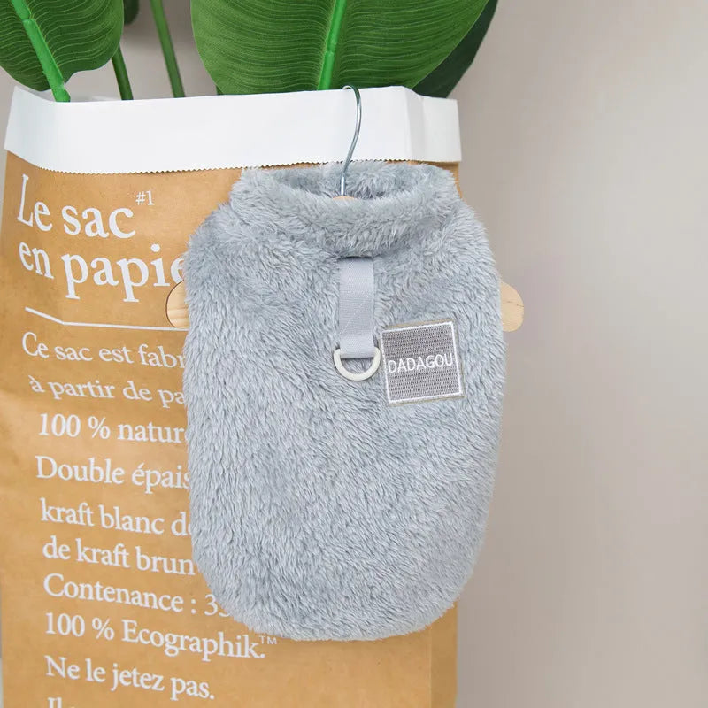A blue coral fleece pet jacket for dogs or cats with a pull-ring fastening, laid flat.