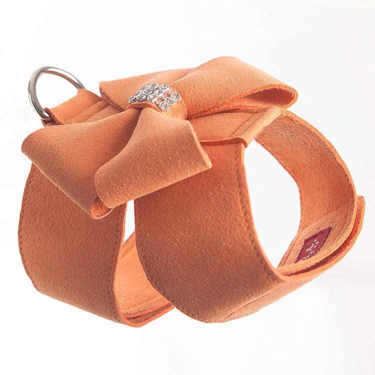 Close-up of a pink microfiber dog chest strap with a white bowknot and an adjustable metal buckle.