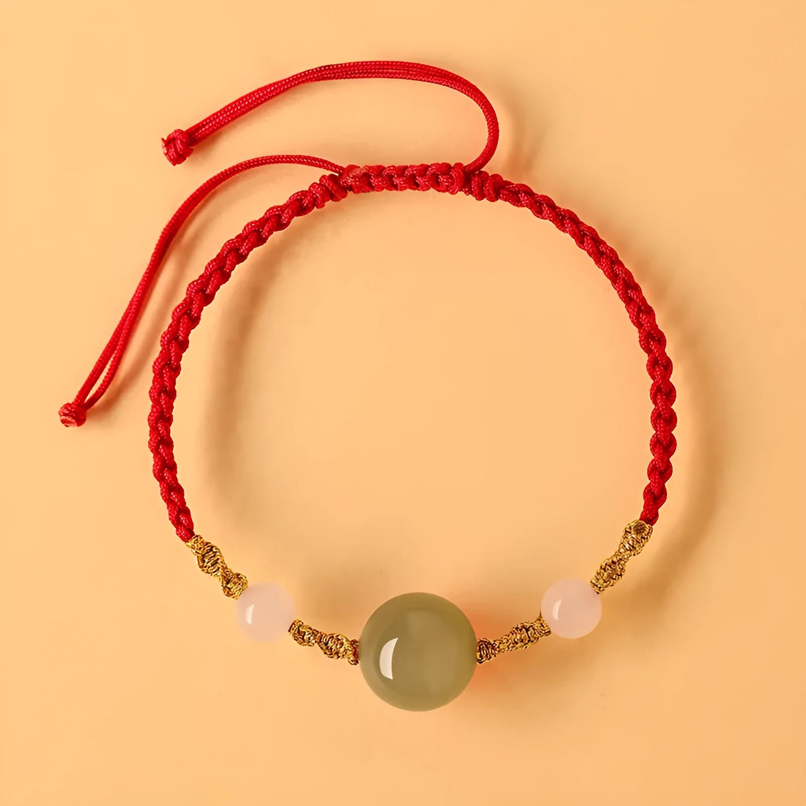 Handwoven Hetian jade lucky beads bracelet with red rope and cultural charm symbols in ethnic style