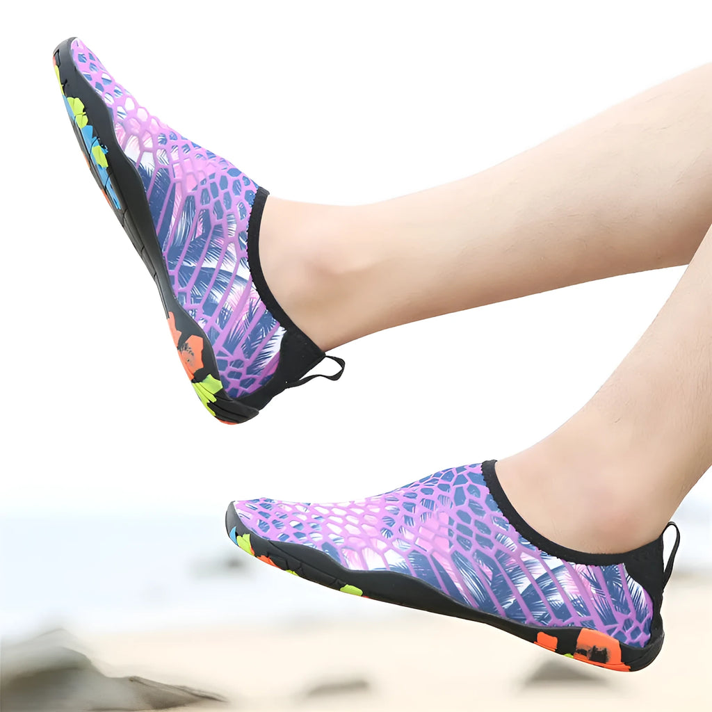 Blue Lycra beach wading shoes for men and women on a sandy shore.