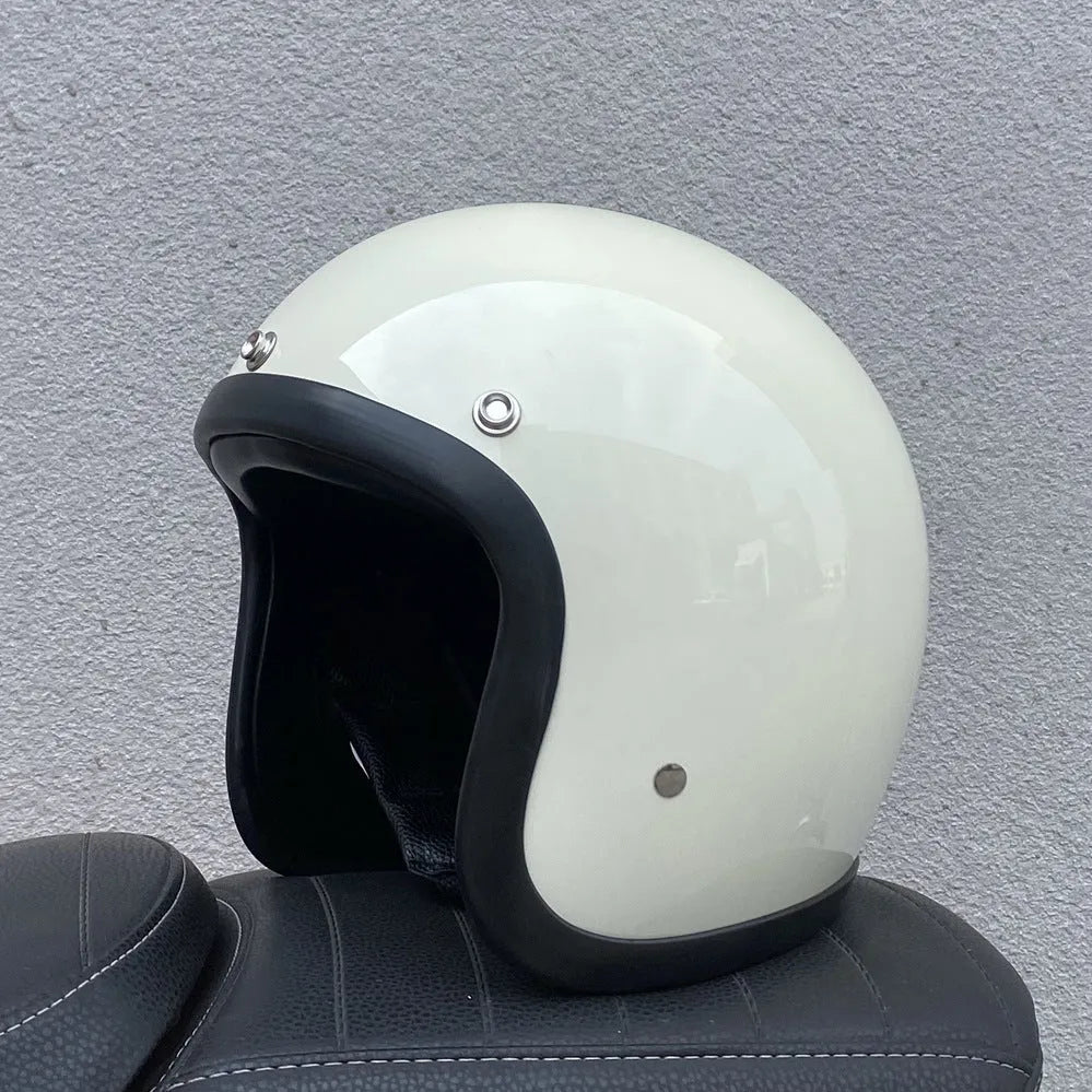 Retro-style open face motorcycle helmet in fibreglass, shown in a selection of colours including cement grey and matte black.