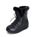 Women's black lace-up ankle boots with a platform sole on a wooden floor.