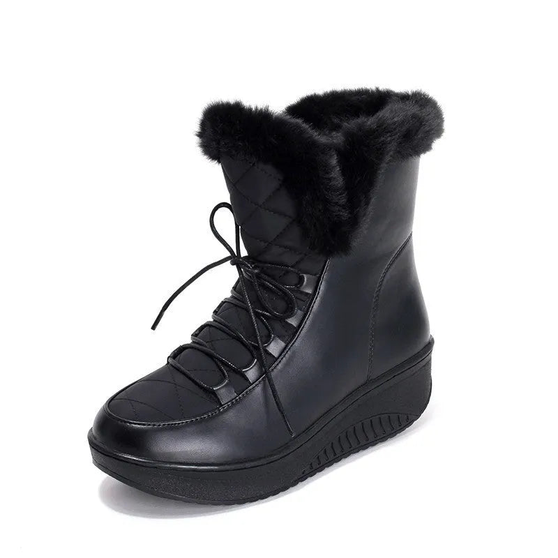 Women's black lace-up ankle boots with a platform sole on a wooden floor.