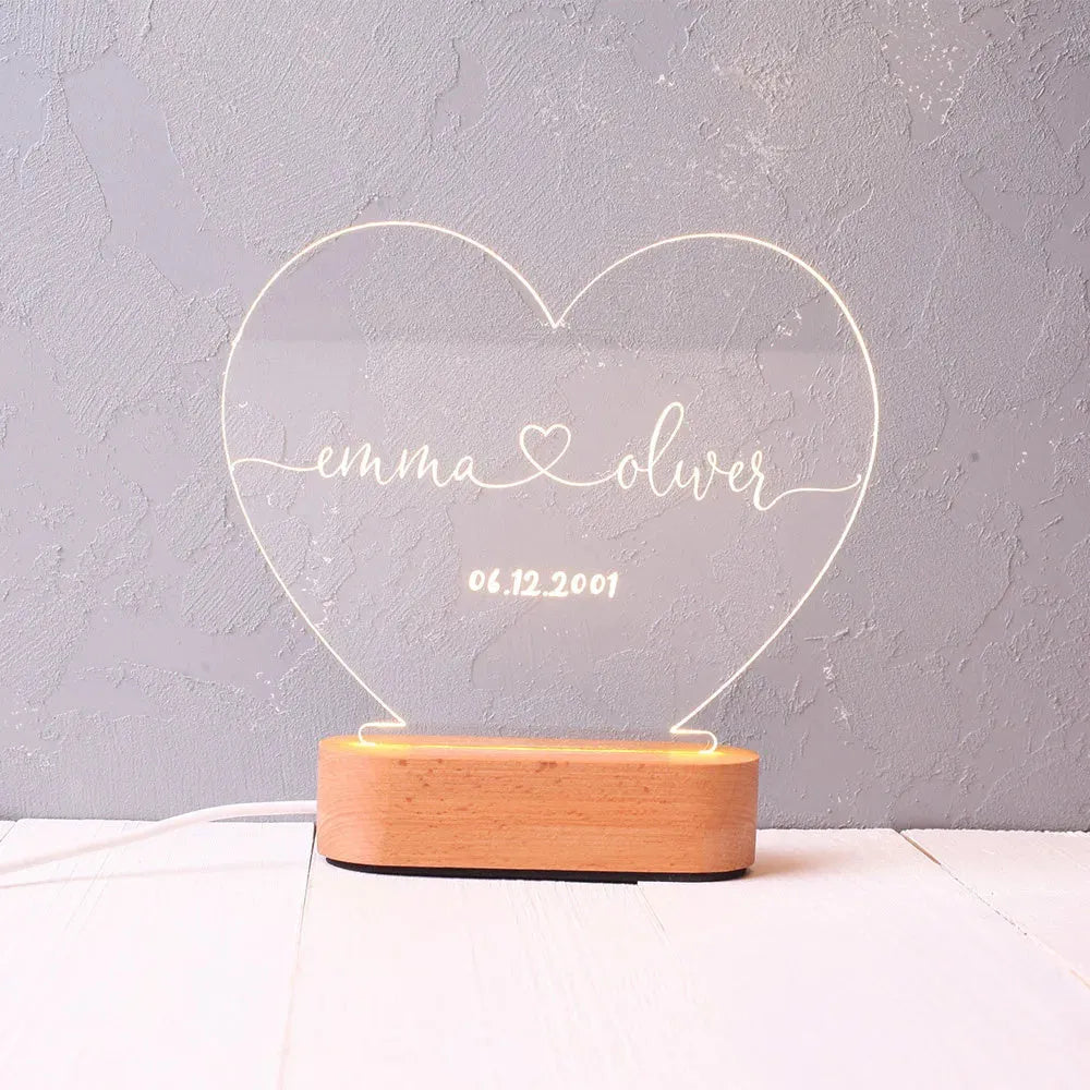 Custom transparent acrylic night light showing personalised names and date, lit by an LED base.
