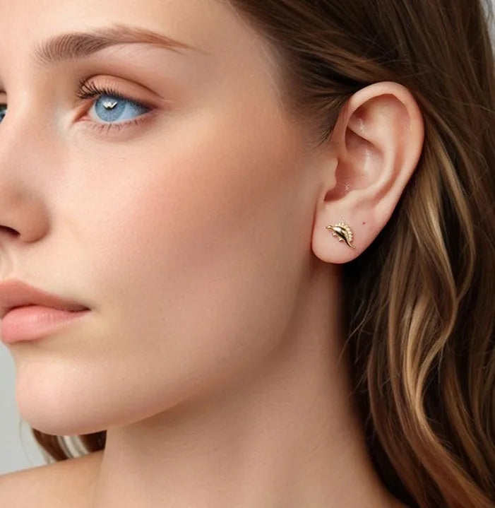 Asymmetric dinosaur stud earrings in 925 silver, animal element design, gold or silver colour option, on a neutral background