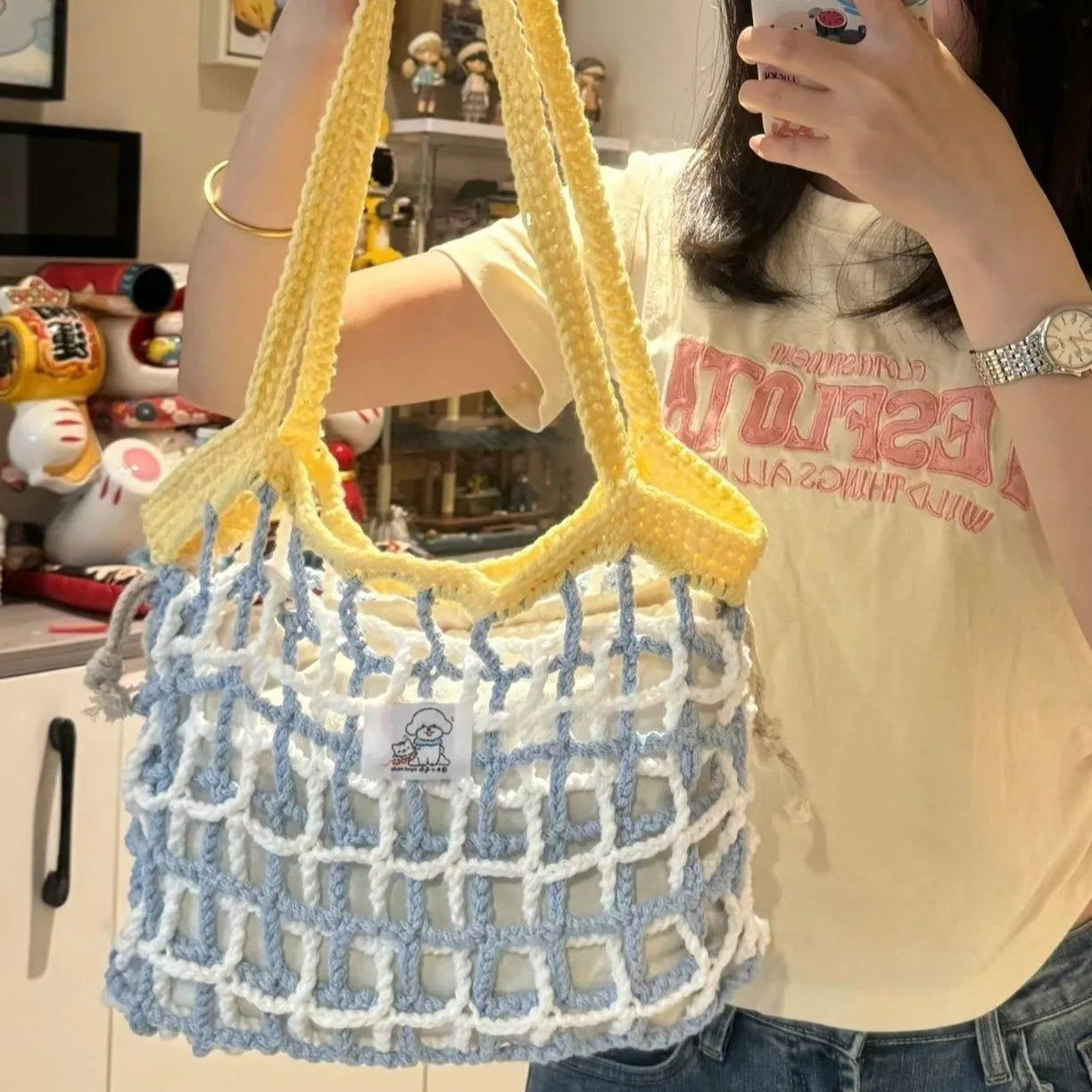 Handmade woven shoulder bag with a floral pattern, made from soft wool yarn.