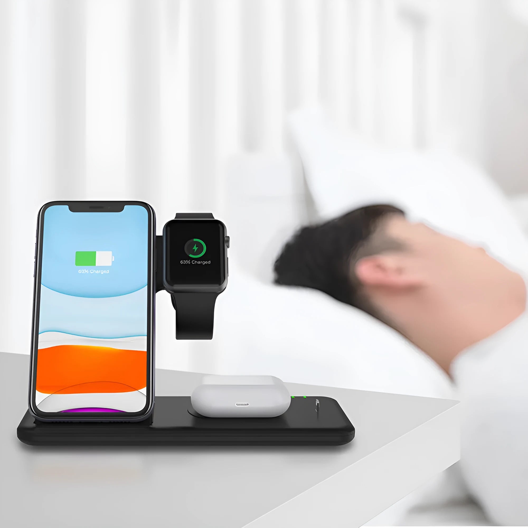 White three-in-one wireless charging stand for phone, watch, and headset on a desk.