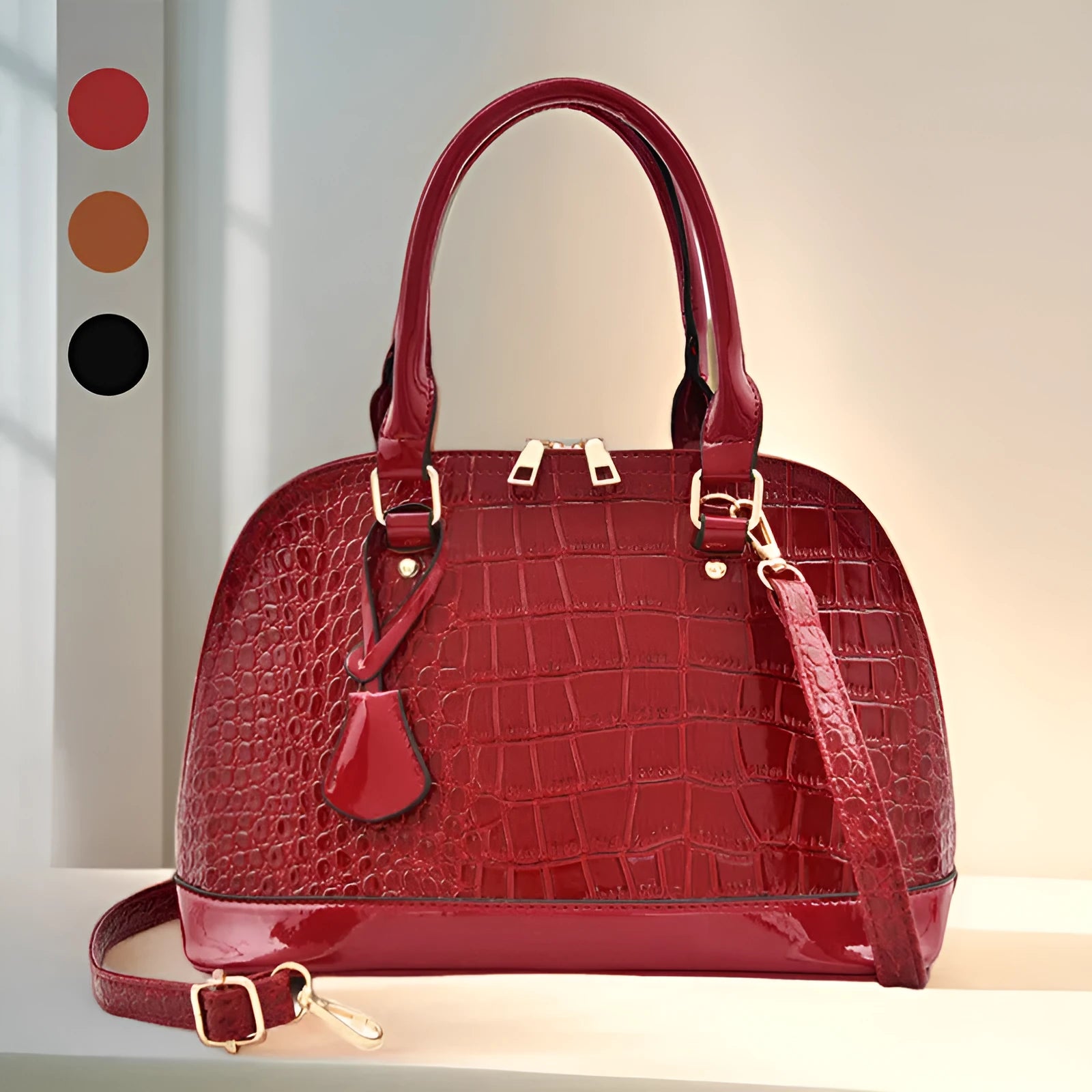 Shiny black shell-shaped crossbody bag showing front view and shoulder strap.
