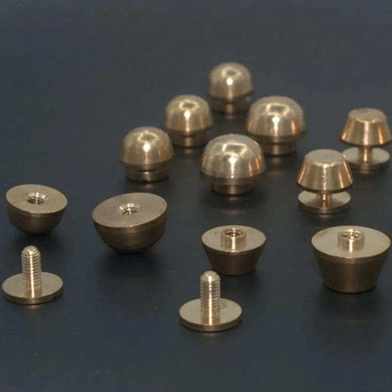Assortment of brass decorative buckles in antique gold finish showing round foot nail and bucket foot nail designs