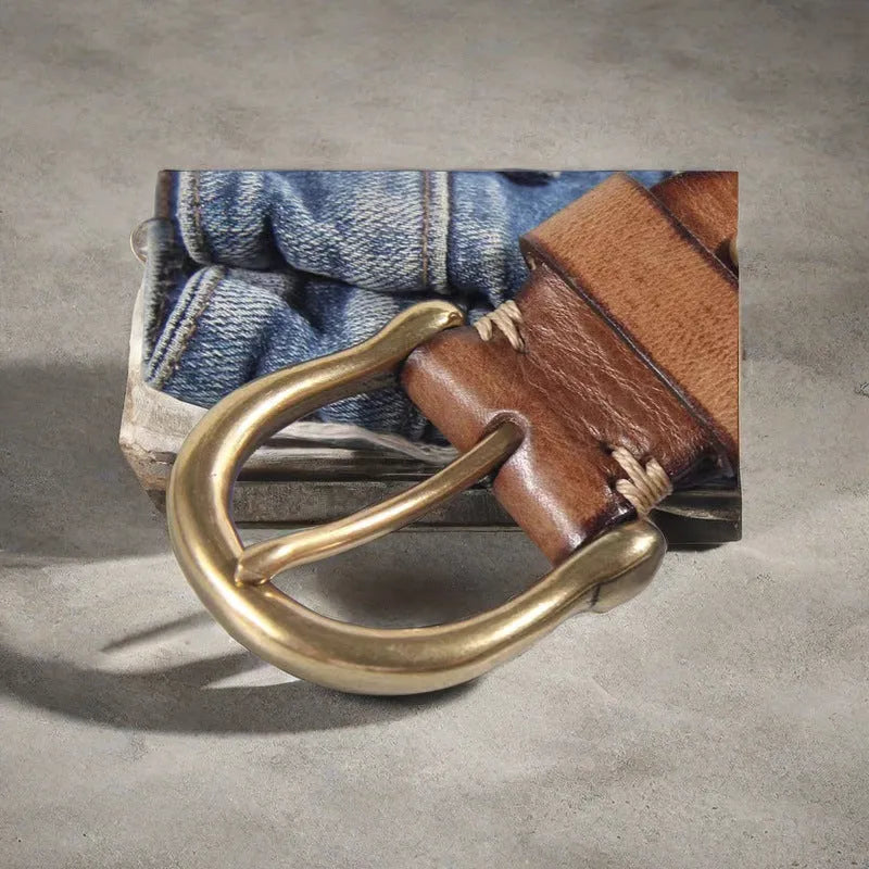 Men's black casual leather belt with copper pin buckle on a jeans background.