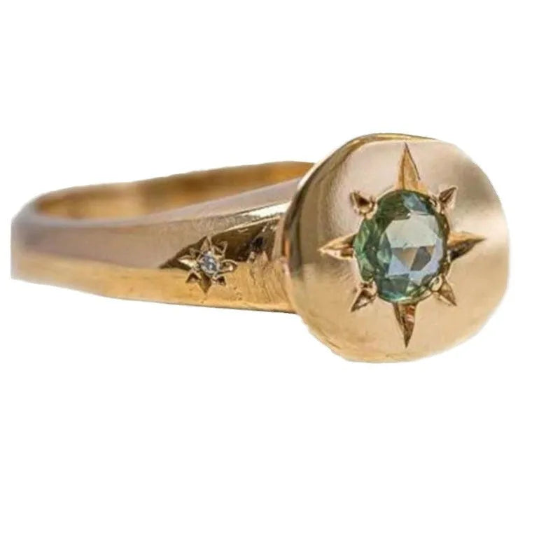 Golden star-shaped adjustable ring with a central oval asterism zircon.