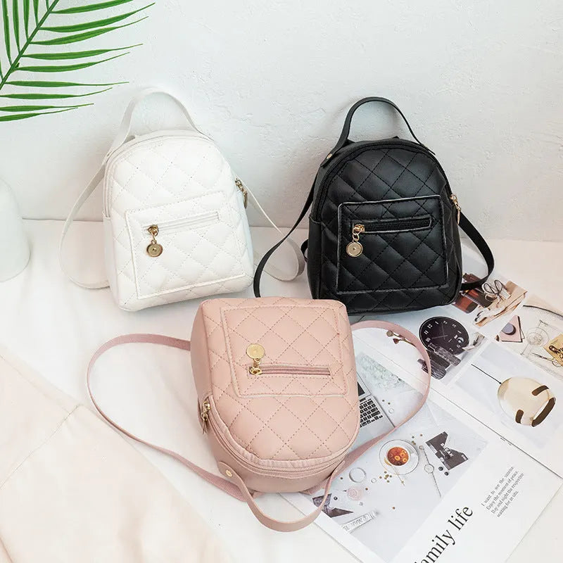 Small white embroidered hardback girls' backpack in a vertical square shape on a plain background.