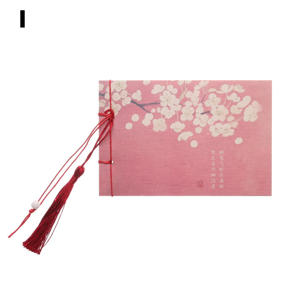 Kraft paper notebook with tassel bookmark showing hand-stitched binding and blank interior pages