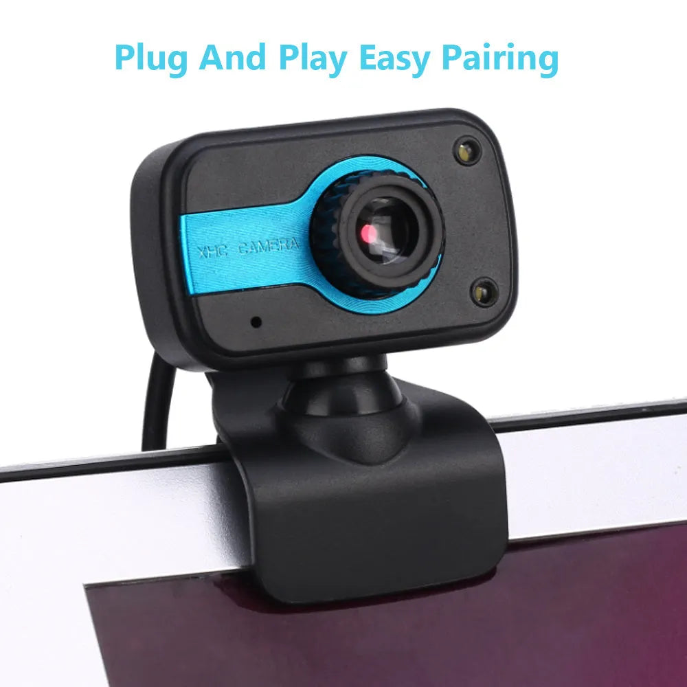 Blue mini USB webcam with a 360-degree rotating head on a desk next to a laptop.